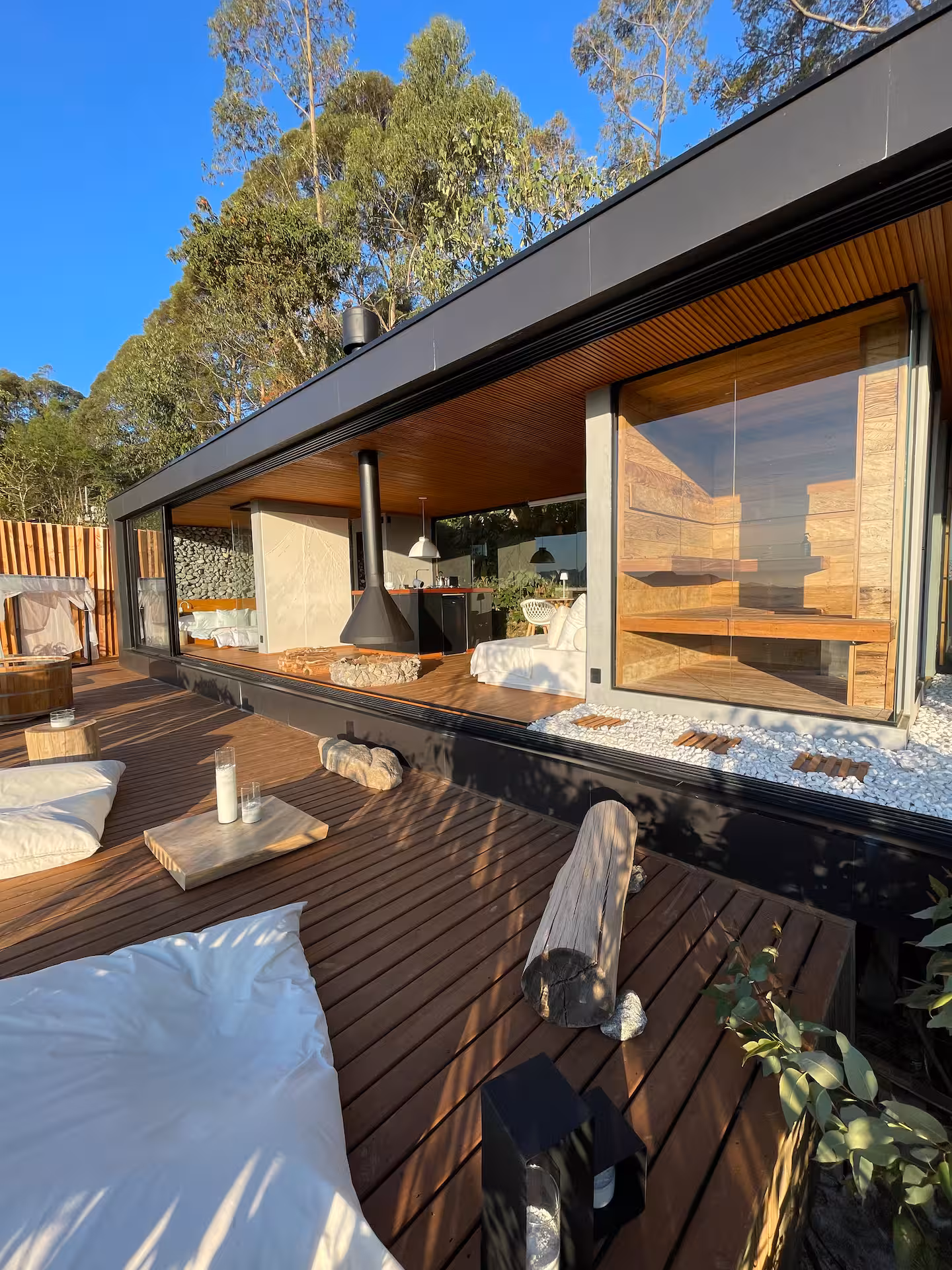 Fachada envidraçada da Casa Spa e deck cercados pela mata