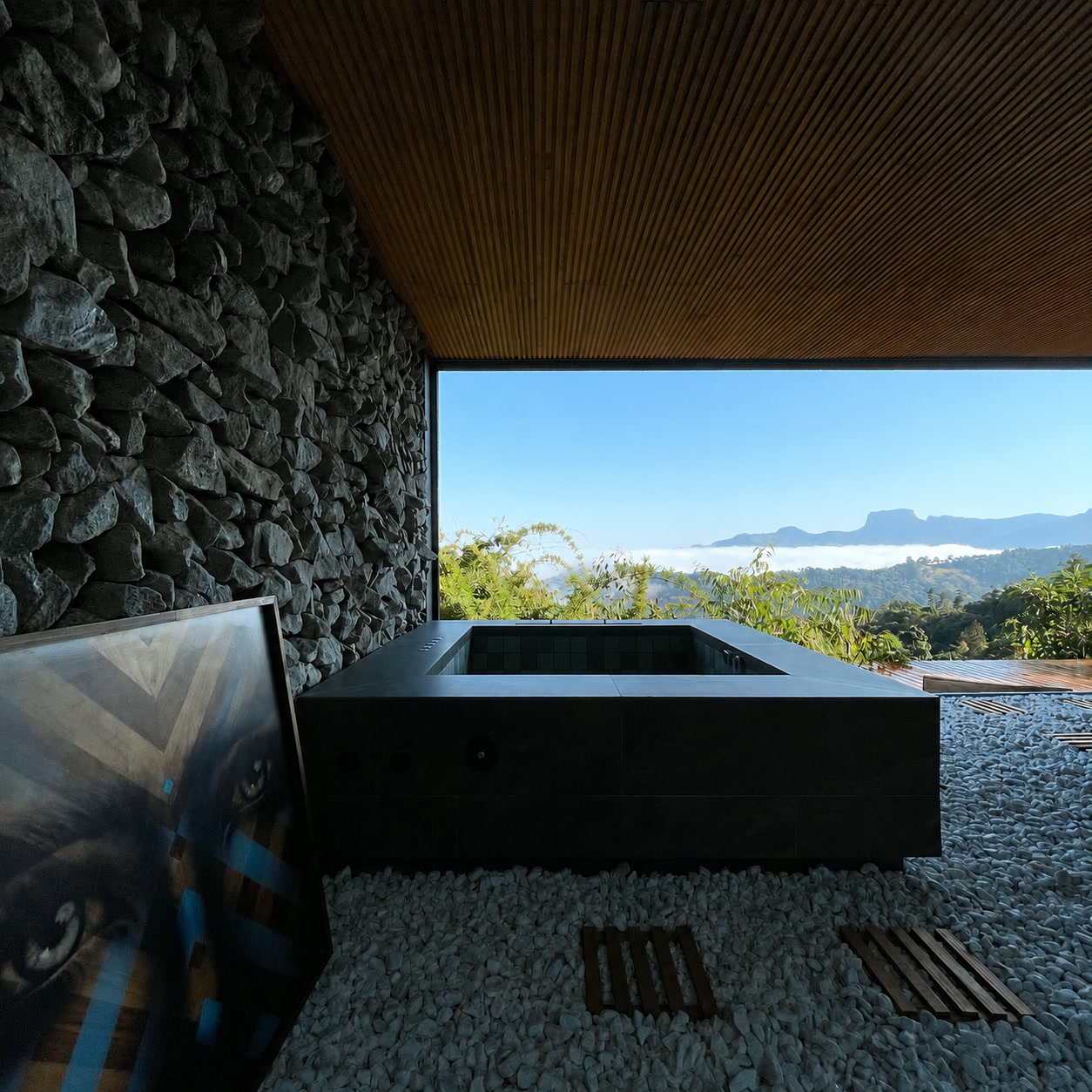 Jacuzzi interna de pedra com vista para a serra sob teto de madeira